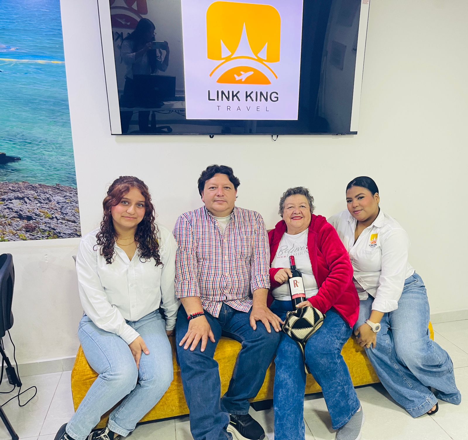 Clientes celebrando su reserva con el equipo de Link King Travel en la oficina